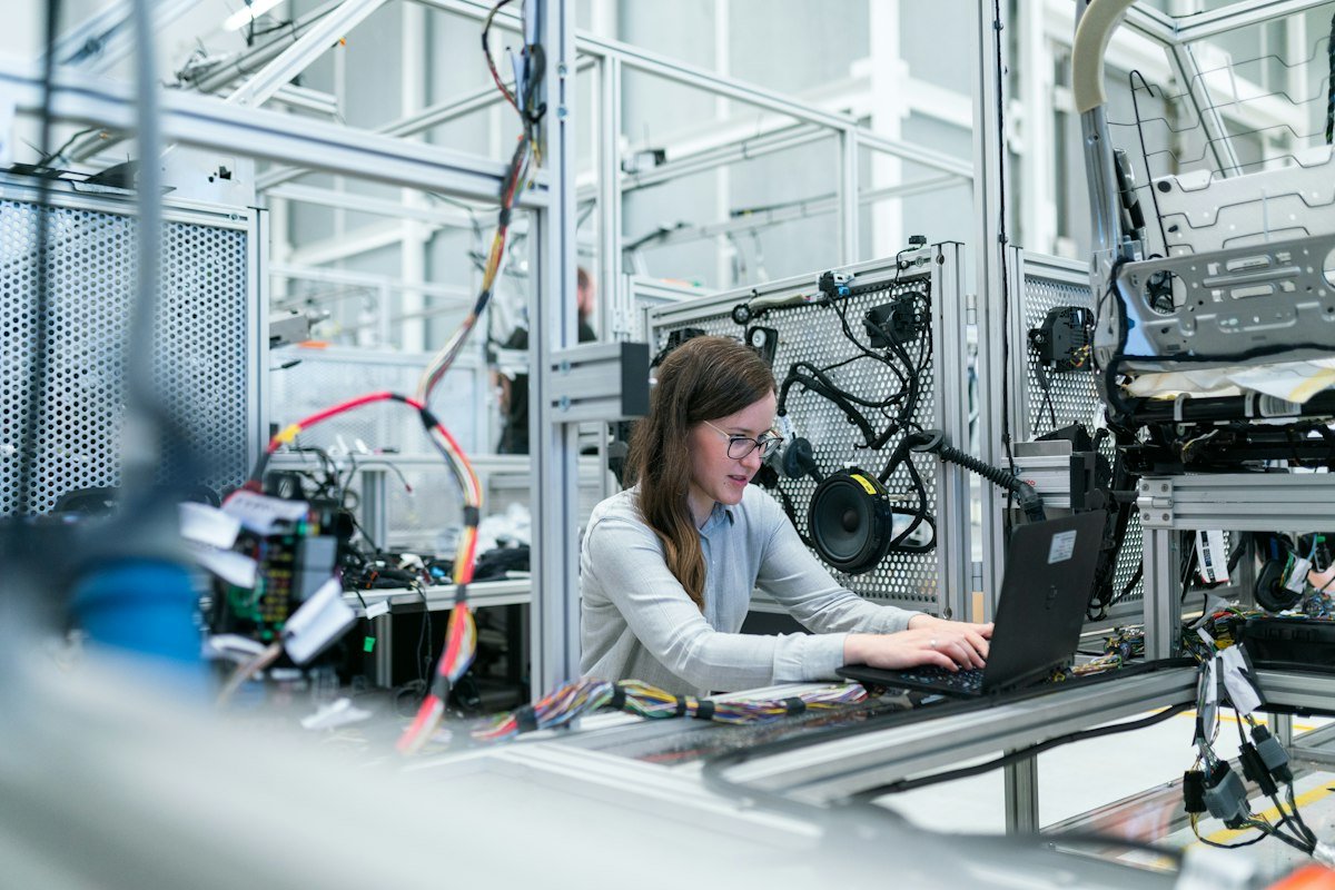 Industrial quality assurance technician inspecting precision milled engineering components with digital calipers under ISO 9001 standards